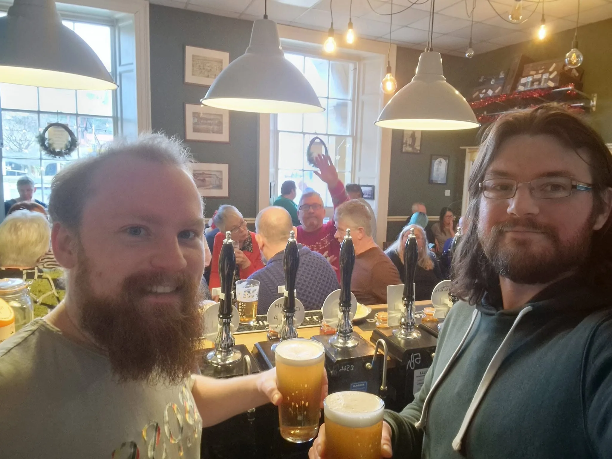 Friends raising pints together inside The Waiting Room